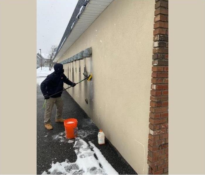 One of our certified technicians cleaning the soot off the building.