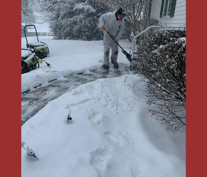 Our SERVPRO technician shoveling snow in a hazmat suit.