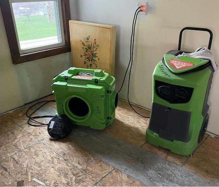 Some of our SERVPRO drying equipment sitting on a ripped up floor after a water damage emergency.