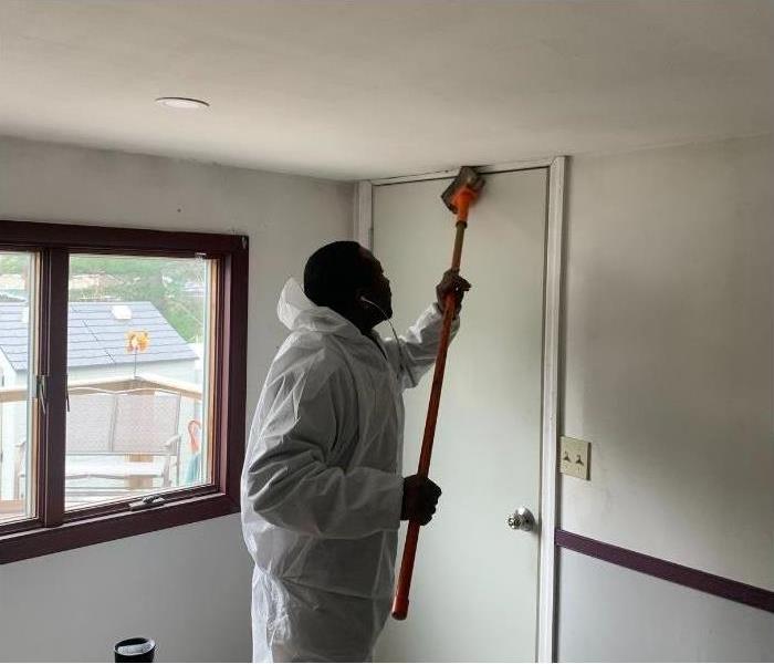 One of our SERVPRO professionals cleaning soot off the ceiling of a Saratoga home.