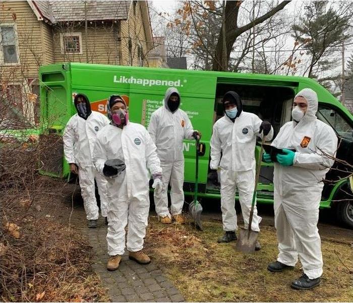 A group of our SERVPRO technicians dressed in hazmat suits standing in front of our truck.