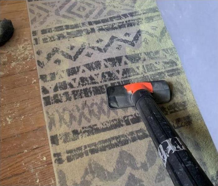 A dirty carpet being cleaned with one of our SERVPRO vacuums.